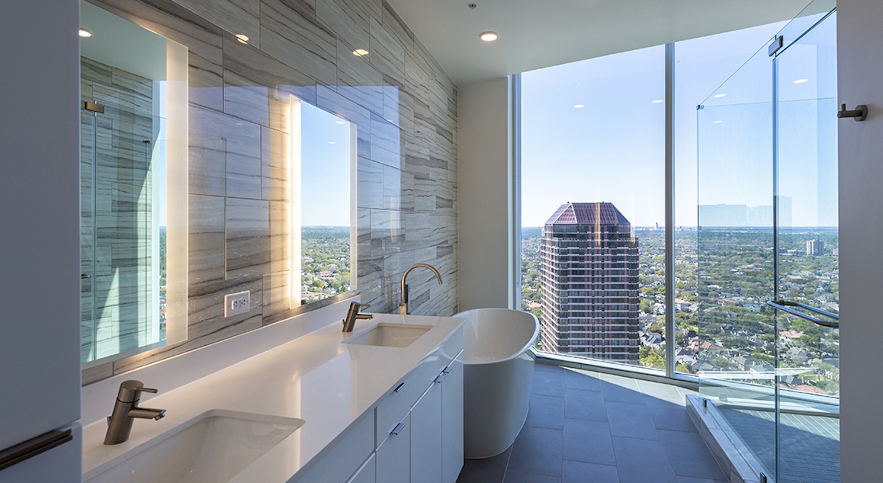 bath areas with marble accents and view of the community