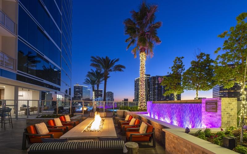 a building with a fire pit and chairs outside